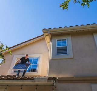 Man fixing solar panels on the roof